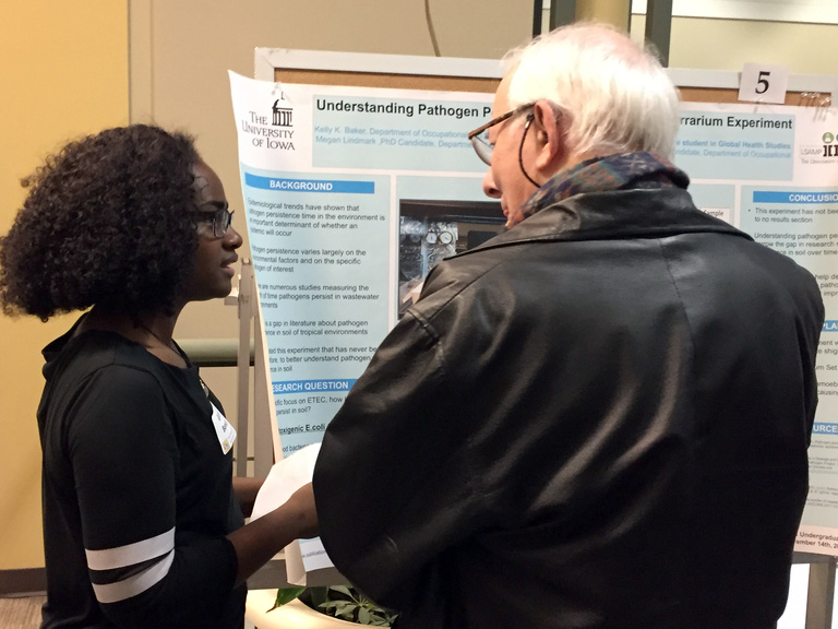 Glorie Borsay, a student in Global Health studies, discusses her research poster with Dr. Squier.