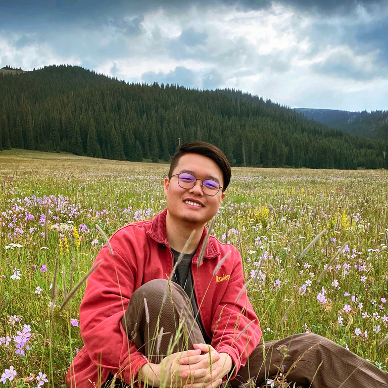 photo of Austin Tang with green hills in background