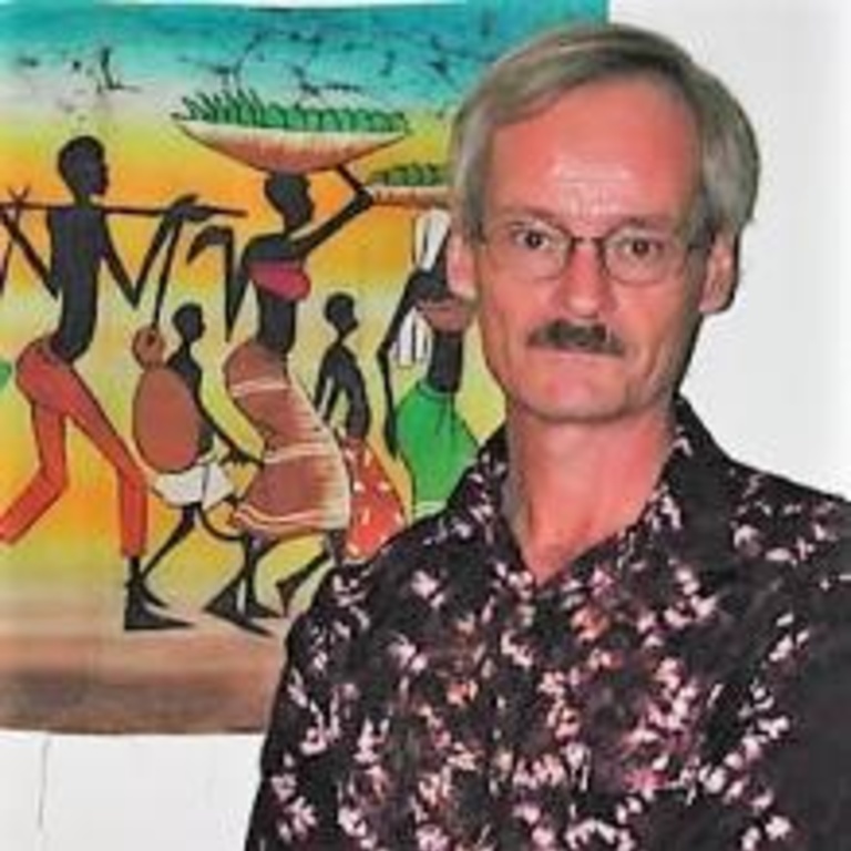 head shot of Jim Giblin in front of a painting of an African community