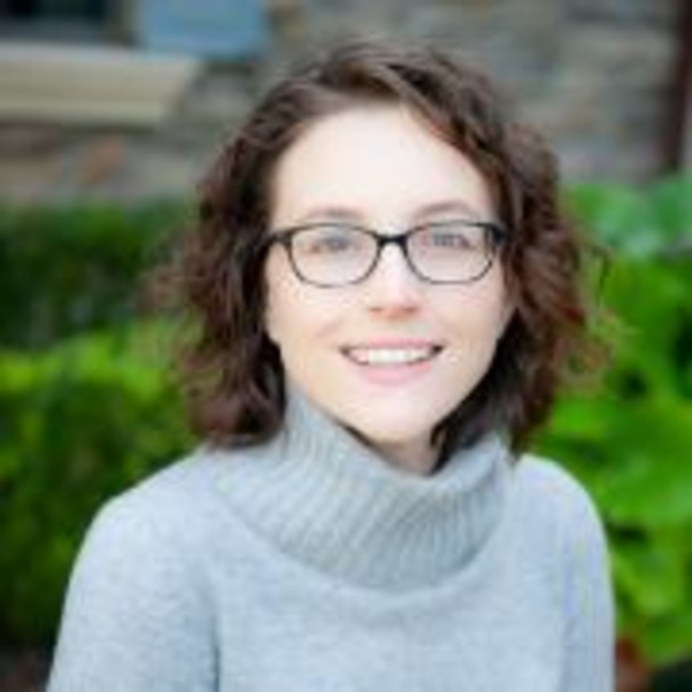 head shot of Maggie Carrell in front of green bushes