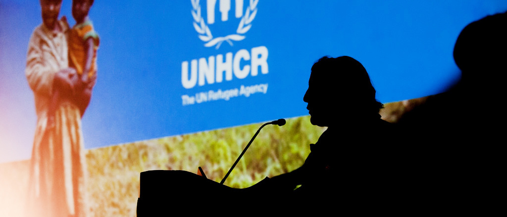 Speaker silhouette against UNHCR screen at GH conference