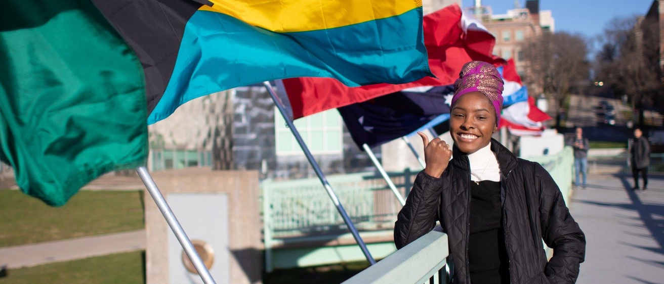 GHS student with international flags on IMU foot bridge